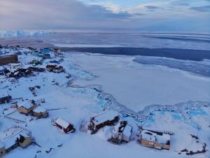 伊卢利萨特Modern seaview vacation house, Ilulissat的雪中村庄的空中景观