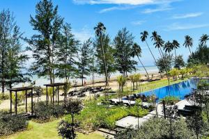 SematanBeachfront Retreats @RoxyBeachSematanApt.的一个带游泳池和棕榈树的度假村