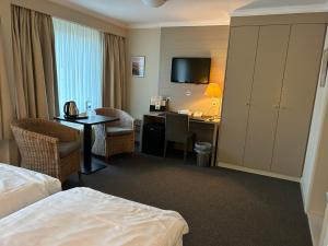 泽布吕赫阿特拉斯酒店的酒店客房配有一张床和一张带电脑的书桌