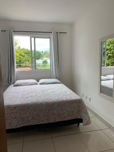 伊列乌斯Apartamento em Ilhéus próximo as Praias的一间卧室设有一张床和一个窗口