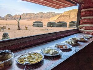 瓦迪拉姆Wadi rum galaxy camp的沙漠中的餐桌上的自助餐