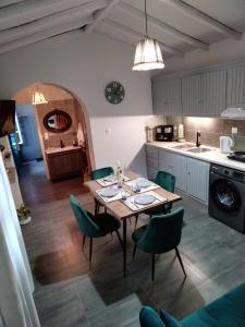 圣帕拉斯凯维Litsa's House Platanias的厨房配有木桌和绿色椅子