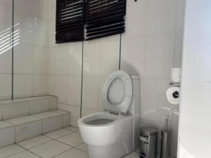 MatolaTR GUEST HOUSE的一间带卫生间和盖的浴室