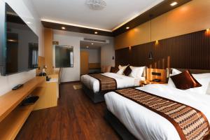 加德满都Prudential Hotel Nepal的酒店客房设有两张床和一台平面电视。
