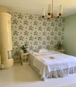 Lantligt boende nära Kastelholms golf och Smakbyn的一间卧室配有一张床和花卉壁纸
