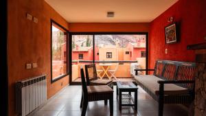 普尔马马尔卡Colores de Purmamarca的阳台配有沙发、桌子和窗户。