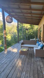 Santa MaríaPewma Lodge Conguillio的木制甲板上配有一张桌子和一张沙发的庭院