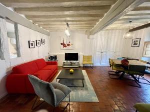 欧塞尔Le Pigeonnier centre historique Auxerre的客厅配有红色的沙发和桌子