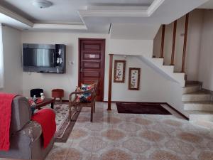 圣若昂-德雷Aconchego Mineiro的客厅配有沙发和墙上的电视