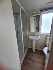 法利Happy Days Caravan Primrose Valley的一间带水槽、淋浴和卫生间的浴室