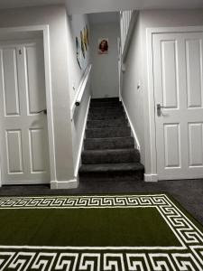爱丁堡Hesed Home的走廊上设有绿色地毯的楼梯