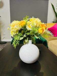 爱丁堡Hesed Home的白色花瓶,桌子上放着一束鲜花