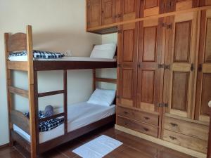 圣若昂-德雷Aconchego Mineiro的客房设有两张双层床和橱柜。