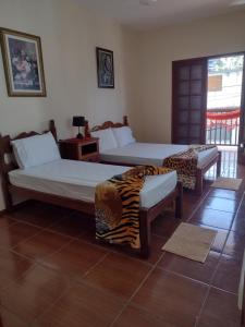 圣若昂-德雷Aconchego Mineiro的配有两张床铺的房间,房间带两张家具