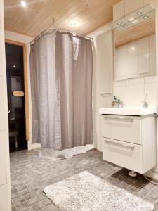于韦斯屈莱Avara, ylellinen kaksikerroksinen huoneisto.的浴室配有淋浴帘和盥洗盆。