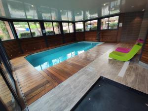翁弗勒尔克洛弗勒里葡萄园 - Spa酒店的一座带绿椅的游泳池