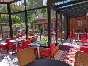 翁弗勒尔克洛弗勒里葡萄园 - Spa酒店的餐厅设有红色的椅子和桌子以及窗户。