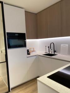 尼乌波特Luxe appartement `t Sant Nieuwpoort Bad的厨房配有白色橱柜和水槽