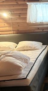 萨伦Bäckstugan的一张带白色床单和枕头的床