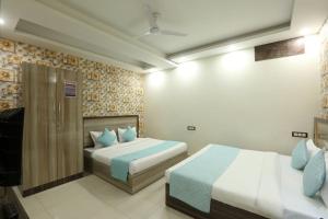 新德里Hotel Amenda Delhi IGI Airport International Mahipalpur的酒店客房 - 带两张带蓝色枕头的床