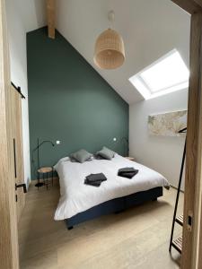 西内La Grange d'Haversin的卧室配有一张白色的大床和天窗。