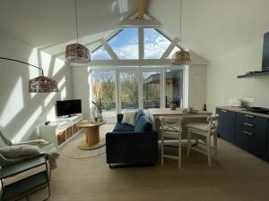 西内La Grange d'Haversin的一间带蓝色沙发的客厅和一间厨房