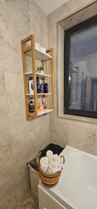 马马亚Iaki Apartment Mamaia的一间带水槽和一篮毛巾的浴室