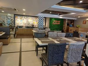 钦奈Hotel Marina Inn Egmore Chennai的一间带桌椅的餐厅和一间酒吧