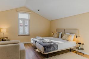 比索达雷加Primeiro Quartel Apartments - 5的一间卧室配有一张大床和一张沙发