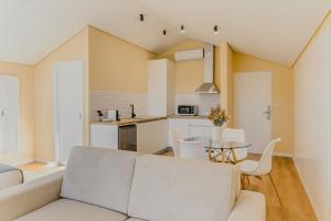 比索达雷加Primeiro Quartel Apartments - 5的客厅以及带沙发和桌子的厨房。