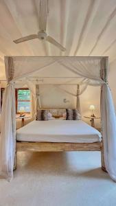 马林迪Villa Marine Park - Malindi的一间卧室配有一张带天蓬的床