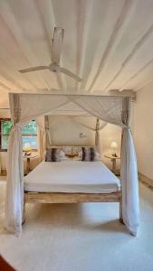马林迪Villa Marine Park - Malindi的一间卧室设有天蓬床和天花板