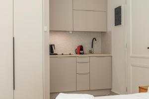 SpílionPanorama Luxury Suites的厨房配有白色橱柜和水槽