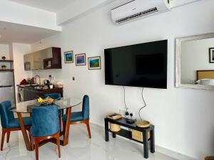 尼甘布Ocean Breeze Hotel Residencies BritLanka Apartments Negombo的客厅配有桌子和墙上的电视