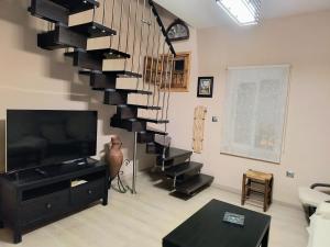 塞维利亚Casa El limonero的客厅设有螺旋楼梯和电视