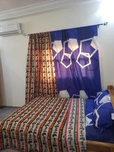 洛美Fafape的一间卧室配有一张带彩色床罩的床