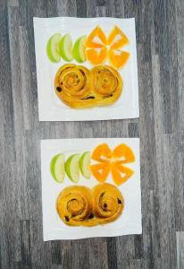 MatolaTR GUEST HOUSE的两盘配橙子和苹果的食物