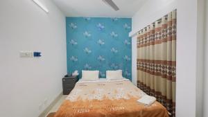 达卡Chittagong Hotel & Apartment Service的一间卧室设有一张床和蓝色的墙壁