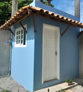 伊塔帕里卡岛维拉克鲁兹Pousada Raio de Sol - Ilha de Itaparica- Catu á 150 m da praia的蓝色的房子,有白色的门和窗户