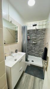 萨莱比梅Carpe Diem Spacieux élégant et confortable appartement idéal pour les séjours professionnels的带淋浴和盥洗盆的白色浴室