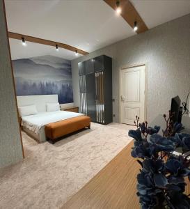 巴库VİVA BOUTIQUE & MIRROR DELUXE HOTEL's BAKU的卧室配有一张床,墙上挂有绘画作品