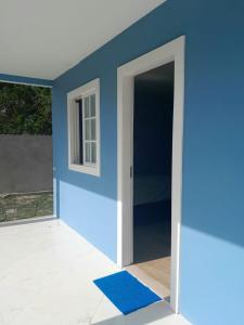 伊塔帕里卡岛维拉克鲁兹Pousada Raio de Sol - Ilha de Itaparica- Catu á 150 m da praia的一间设有蓝色墙壁和开放式门的房间