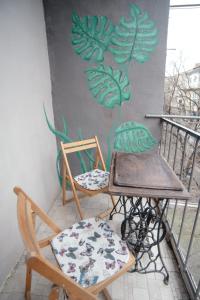 第比利斯Stylish cozy studio guesthouse in the city center的壁画阳台配有两把椅子和一张桌子