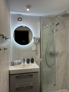 雷瓦Domek Bałtycki Lux的浴室配有盥洗盆和带镜子的淋浴