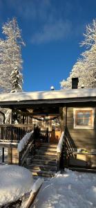 埃斯波Sauna cabin in the heart of Nuuksio National Park的雪覆盖门廊和楼梯的房子