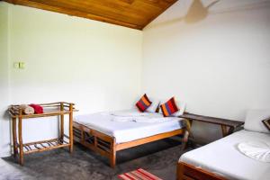 基图尔格勒Extream Adventures of Sri Lanka的一间设有两张床和一张桌子的房间