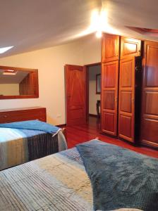 阿科达卡列塔Casa Câmara的一间卧室设有两张床和木制橱柜。