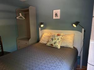 Murray HarbourForest & Lake PEI Cottages的一间卧室配有一张带枕头和两个灯的床