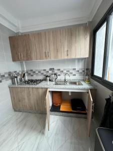 胡塞马Al Hoceima Mini Villa的一个带木制橱柜和水槽的厨房
