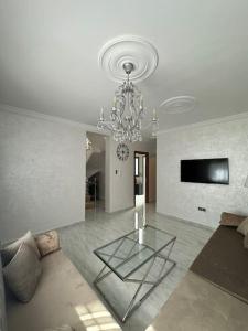 胡塞马Al Hoceima Mini Villa的客厅配有吊灯和玻璃桌